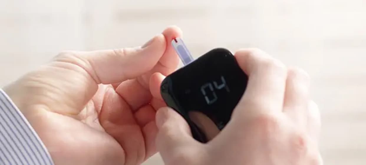 A picture of a hand holding a diabetes monitoring device.