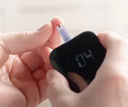 A picture of a hand holding a diabetes monitoring device.